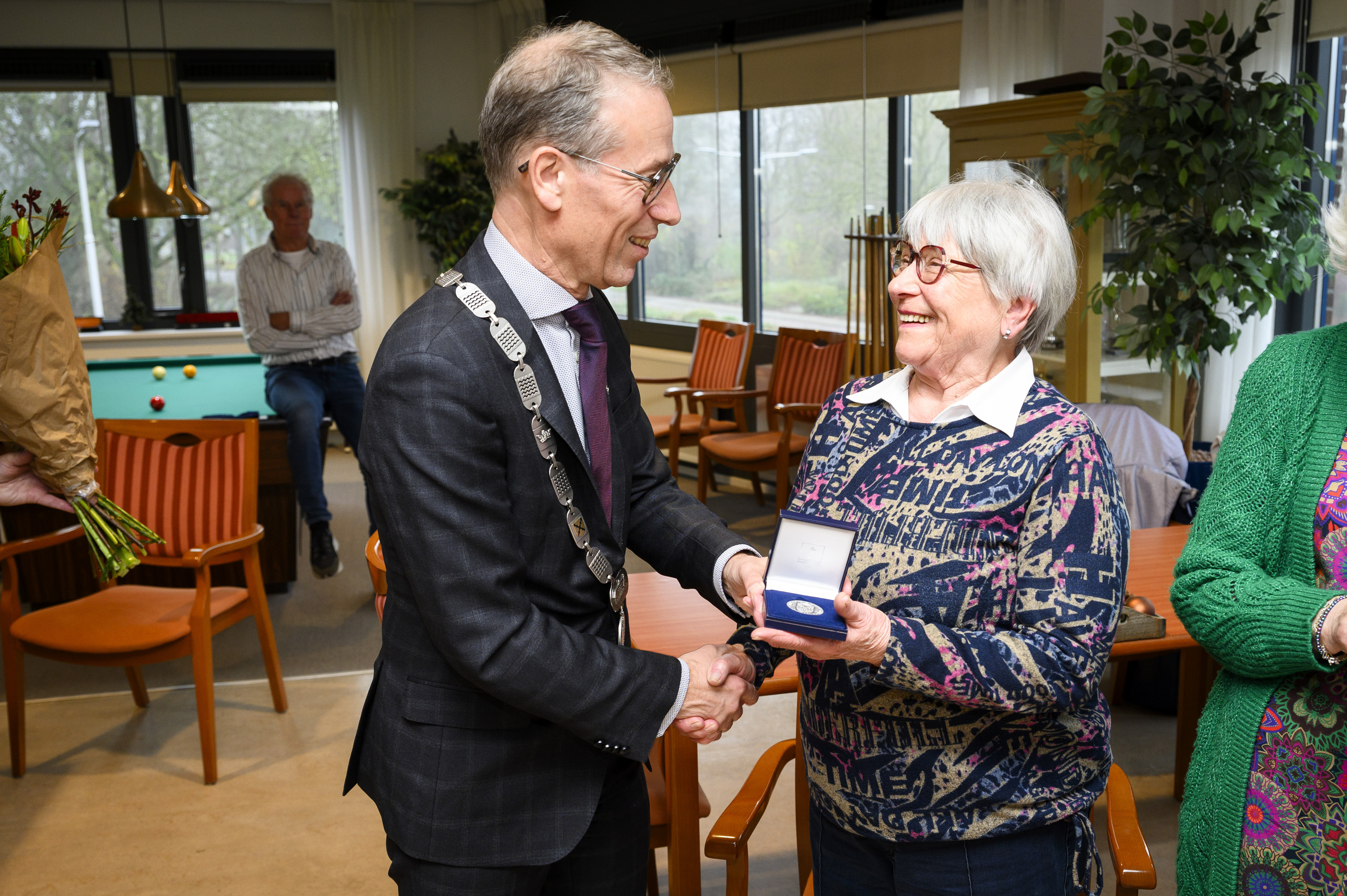 Mevrouw Gerda van Oort ontvangt de gemeentepenning uit handen van burgemeester Jan de Vries