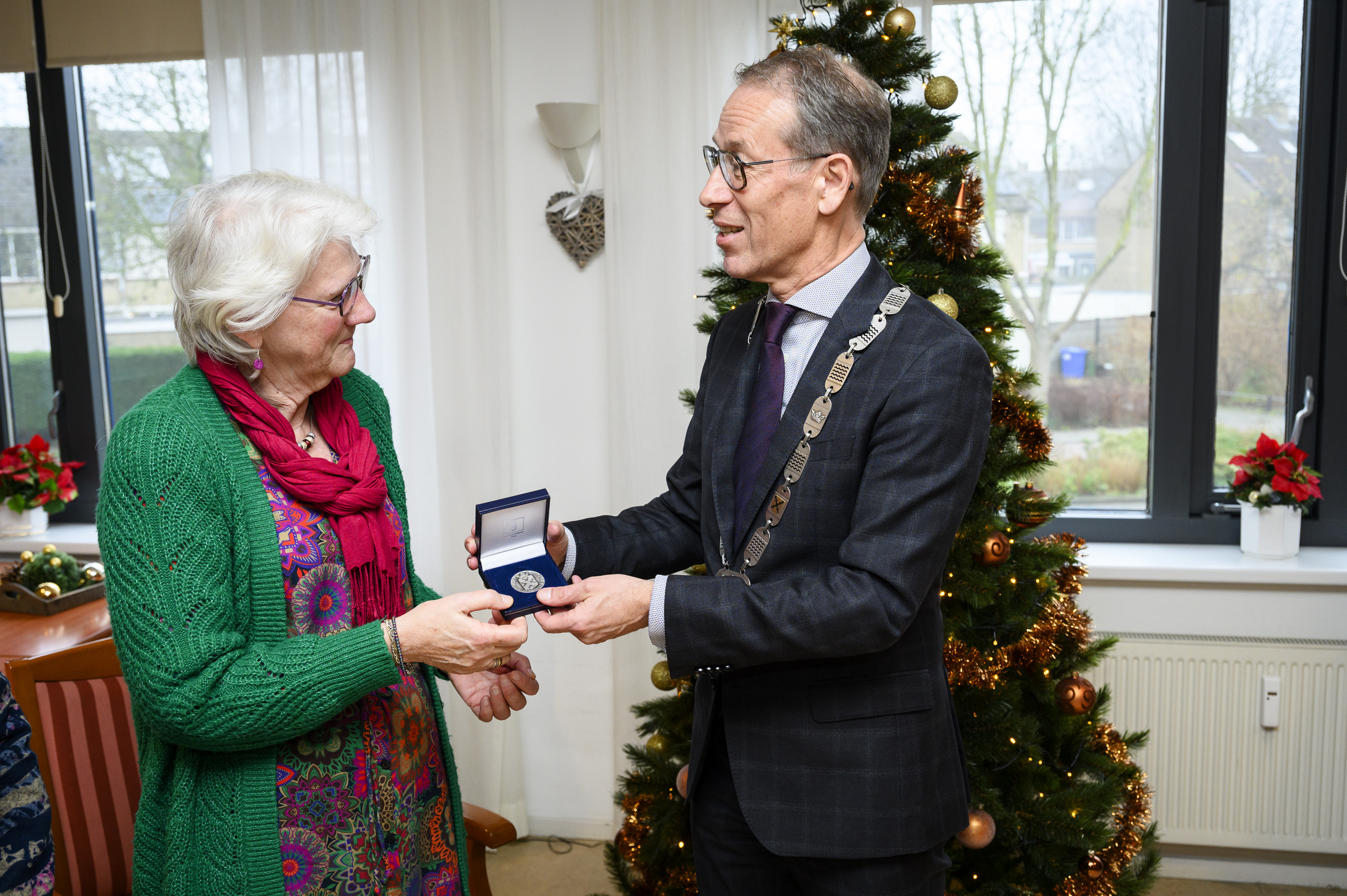 Mevrouw Jennie Rijneveld ontvangt de gemeentepenning uit handen van burgemeester Jan de Vries