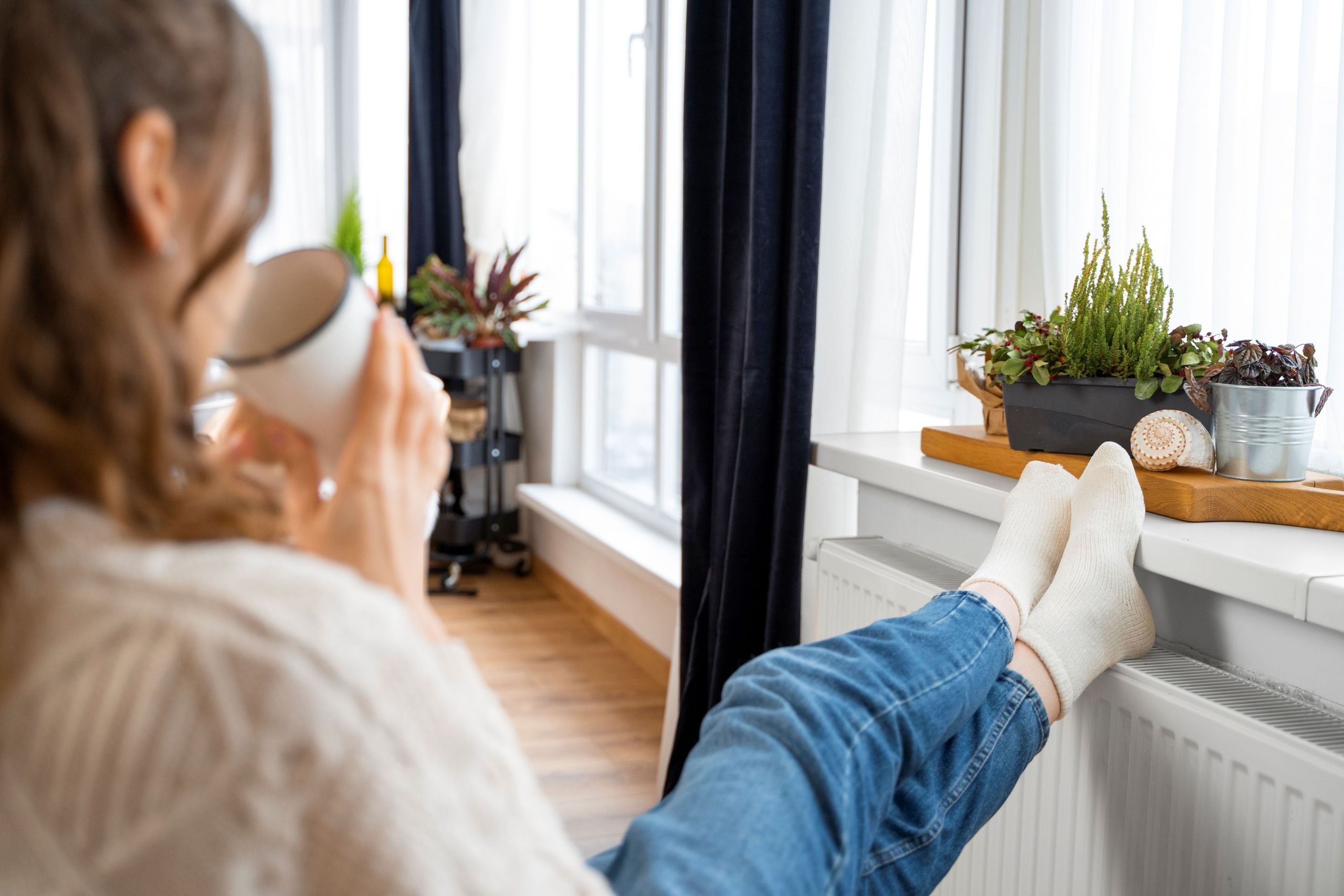 Foto van een vrouw met voeten op de verwarming